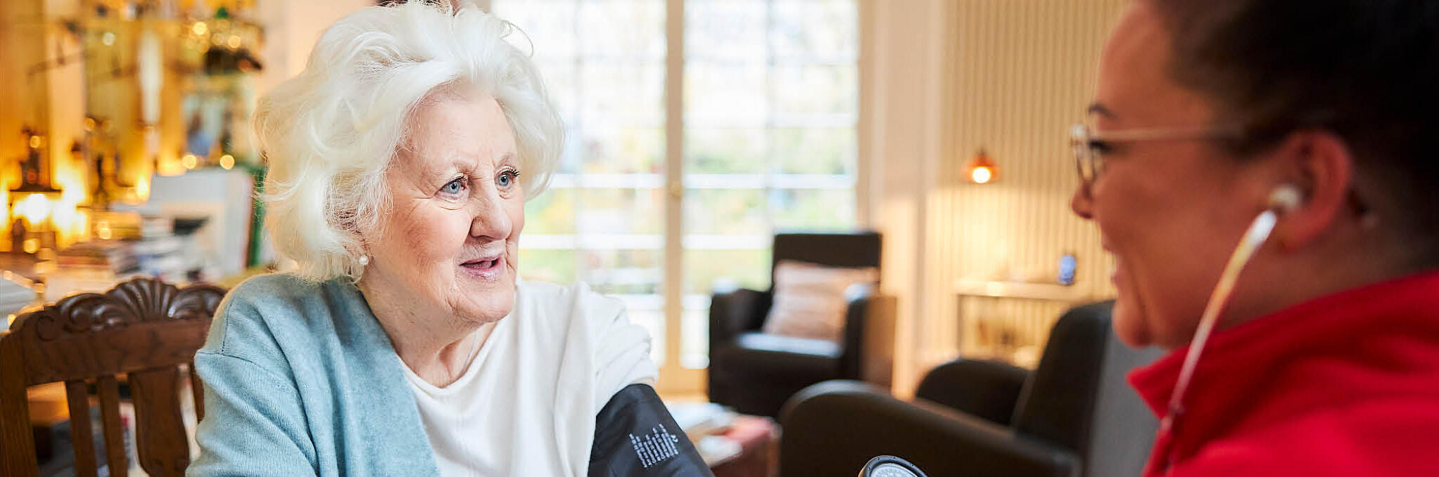 Eine ältere Frau wird von einer Johanniter-Mitarbeiterin untersucht