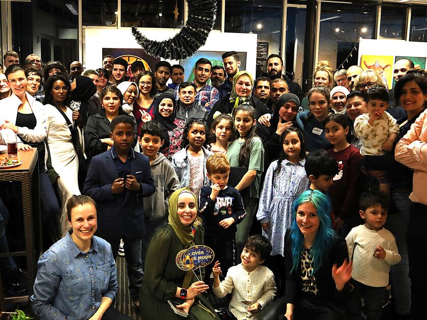 Menschen aus verschiedenen Ländern posieren für ein Gruppenfoto.