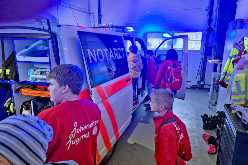 Mehrere Kinder stehen um einen Rettungswagen in der Rettungswache Einbeck drumherum