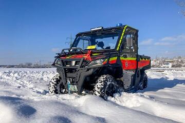 Ein geländegängiges Einsatzfahrzeug der Johanniter mit rot-gelber Beklebung steht im tiefen Schnee, unter blauem Himmel.