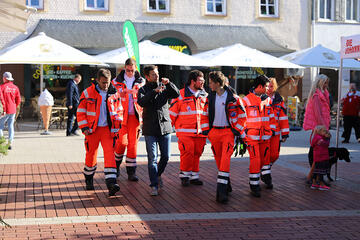Mehrere Einsatzkräfte der Johanniter aus Speyer laufen eine Straße entlang.