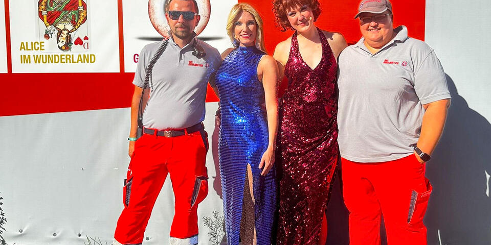 Zwei Johanniter neben zwei Schauspielerinnen