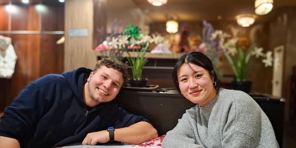 Ein junger Mann und eine junge Frau sitzen in einem Restaurant an einem Tisch.