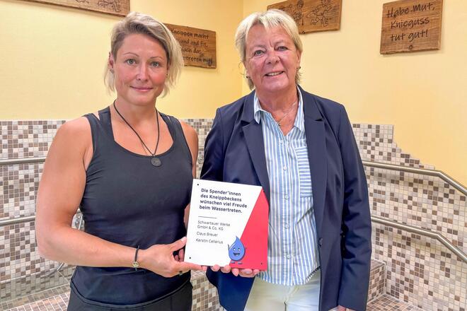 ita-Leiterin Tina Pötzl und Kerstin Cellarius halten ein Spendenschild hoch.
