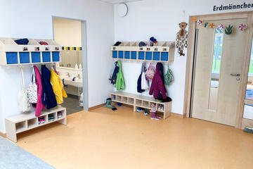 Eine Garderobe in einer Kita mit Kinderschuhen und Kinderjacken