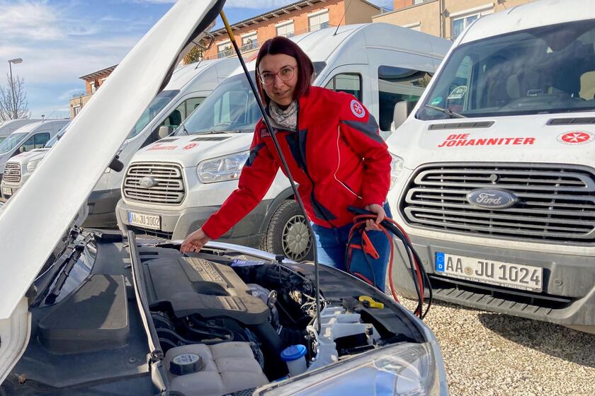Johanniterin an offener Motorhaube