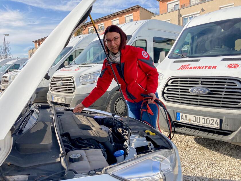 Johanniterin an offener Motorhaube