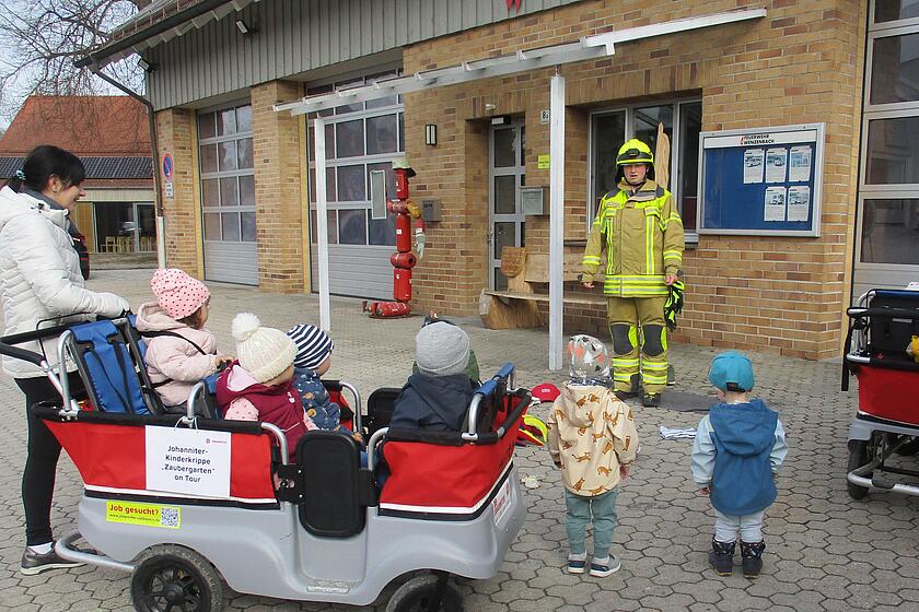 Kinder hören dem Feuerwehrmann aufmerksam zu