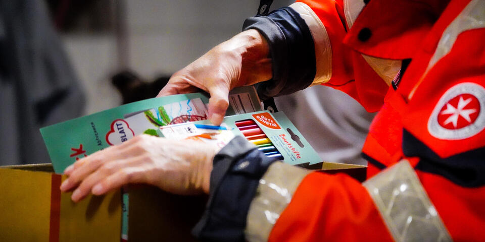 Hände packen Bundstifte in Pakete