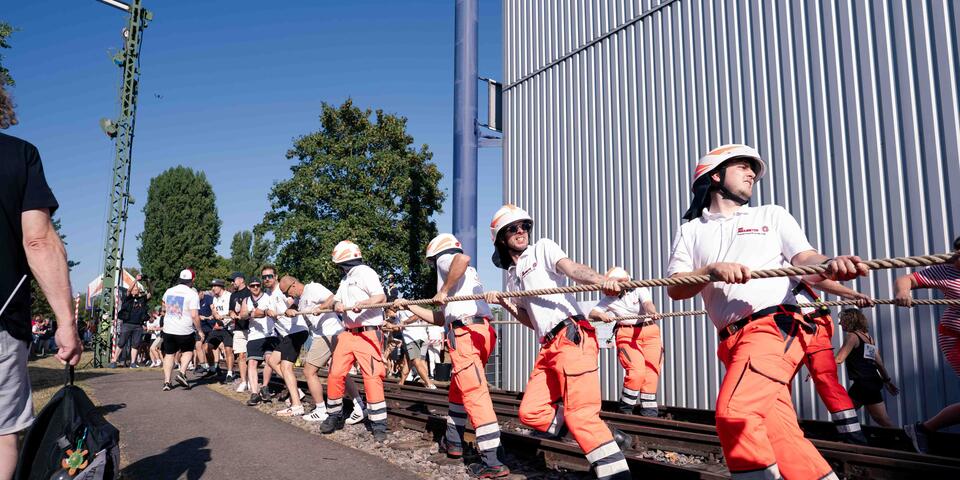 Johanniter ziehen an einem Strang die Lok vor dem Technikmusem Speyer.