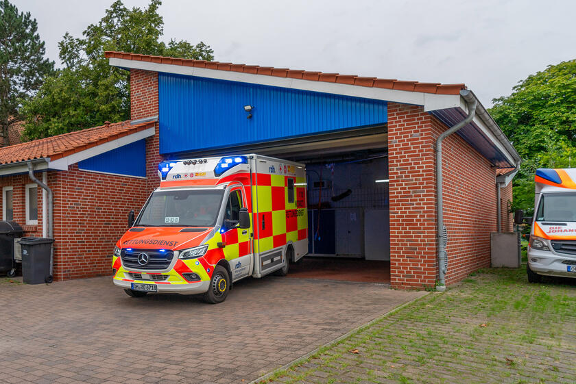 Ein Rettungswagen fährt mit Blaulicht aus der Fahrzeughalle der Rettungswache Cismar.