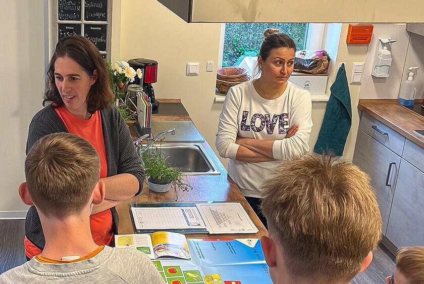 Ernährungsberaterin Susanne Kruse (l.) erklärte den Kindern und Jugendlichen, die im Wohnhaus der stationären Jugendhilfe leben, was gesunde Ernährung bedeutet und wie sie selbst herausfinden können, was in Lebensmitteln enthalten ist.
