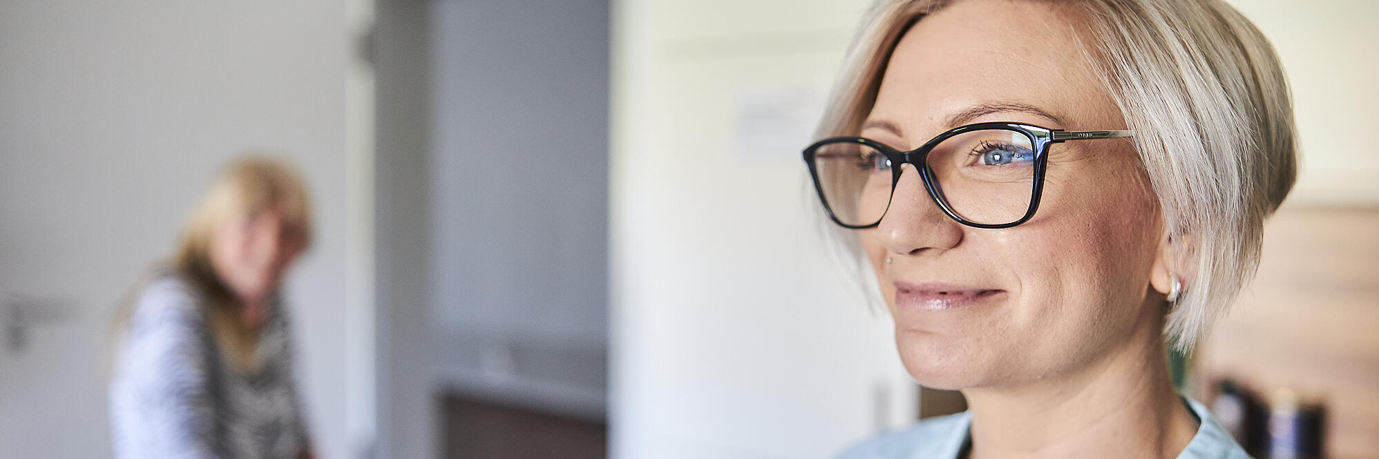 Eine Frau lächelt in den Raum.