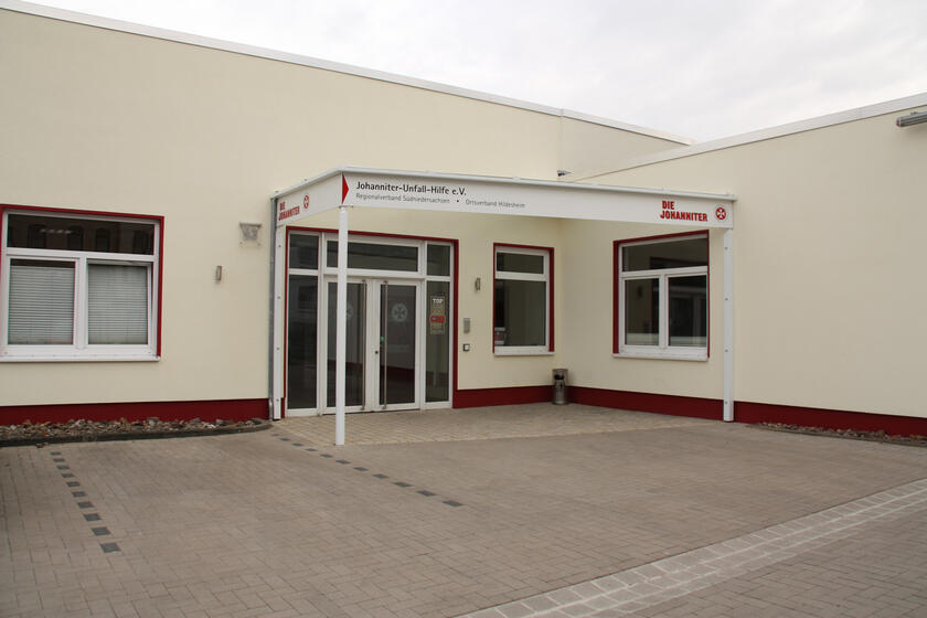 Gelbes Flachdachgebäude mit überdachtem Eingang