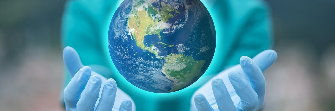 Weltkugel in Händen mit Handschuhen