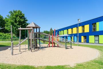 Außengelände mit Spielgeräten und Sandkasten der Johanniter-Kita Seehüpfer