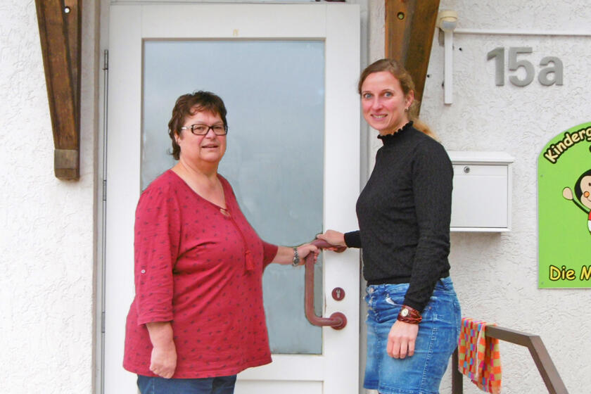 Ehemalige und neue Kita-Leiterin geben sind die Hand vor der Tür der Kita Hoppetosse.