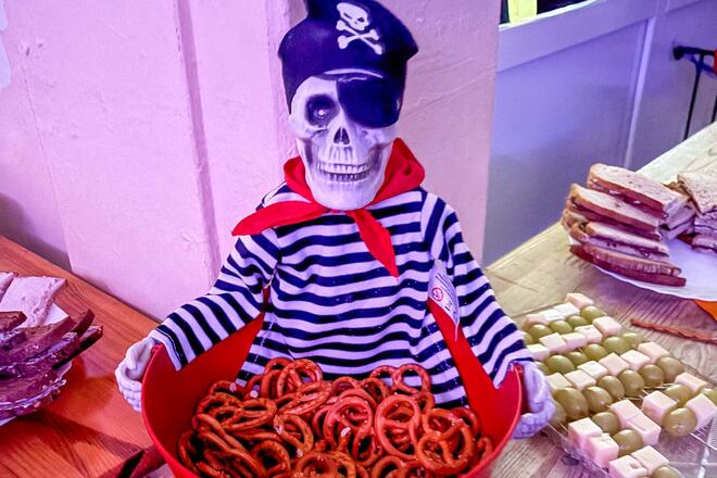 Das Buffet bei der Halloween-Party in der Johanniter-Kita Traumland wurde von den Eltern der Kinder organisiert. Ein Figur (Skelett-Pirat) hält eine Schüssel mit Mini-Brezeln.