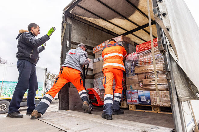 Johanniter laden eine Palette an Weihnachtstrucker Paketen in einen LKW ein.