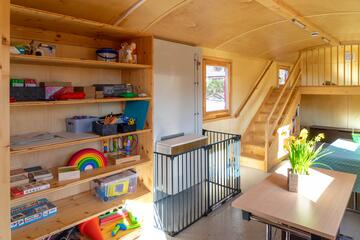 Im Bauwagen des Naturkindergartens Oststeinbek der Johanniter: Ein Schrank mit Spielsachen und Tische zum Sitzen.