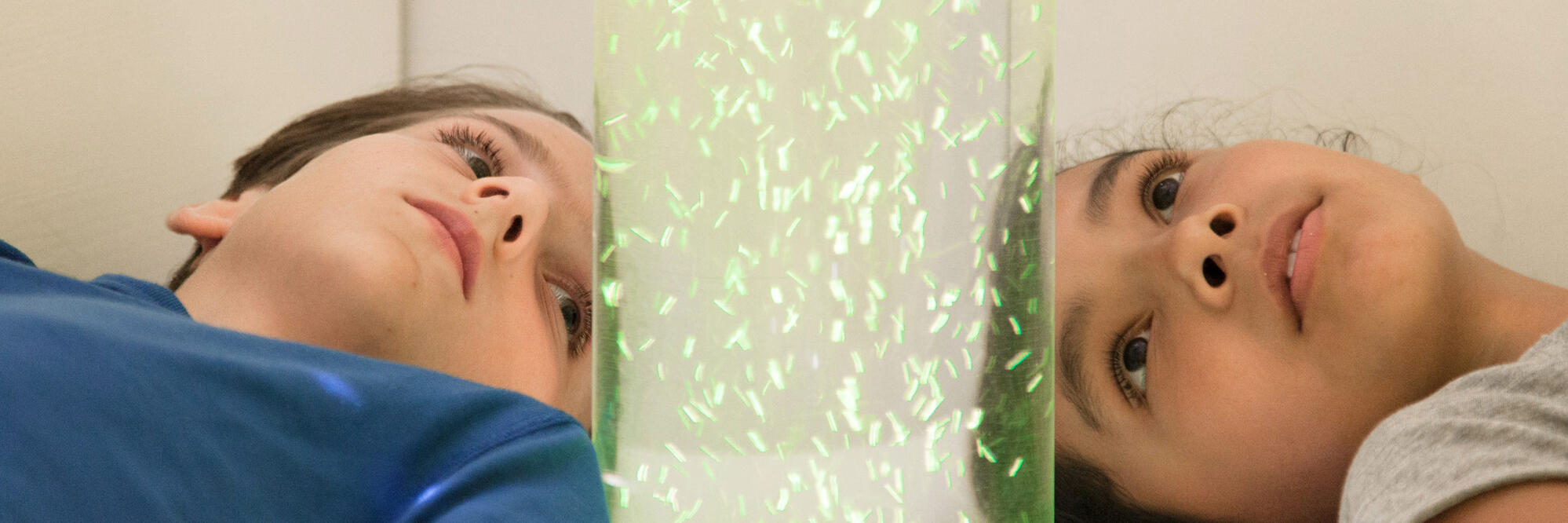 Zwei Kinder einer Lacrima Gruppe schauen sich eine Wasserblasensäule an.