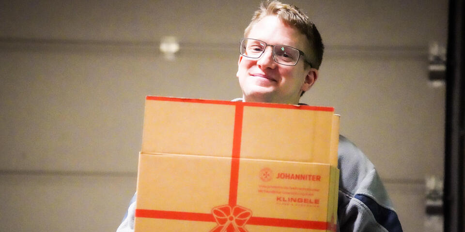 Ein Mann mit einem Weihnachtstrucker-Paket