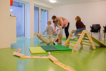 Kinder sind mit Erzieherinnen im Turnraum und spielen