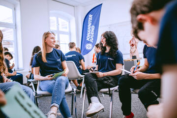 Zwei junge Frauen der Johanniter-Jugend unterhalten sich miteinander in einem Stuhlkreis.