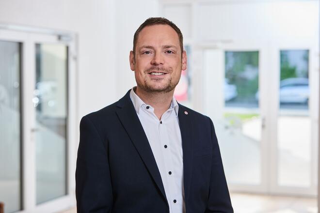 Ein Mann mit weißem Hemd und blauem Sakko