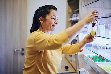 Pflegefachkraft beim Vorbereiten eines Medikaments 