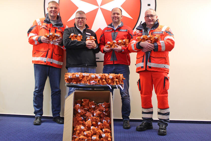 Johanniter und Ameos-Mitarbeiter präsentieren die kuscheligen rotbraunen Stoff-Eichhörnchen. 