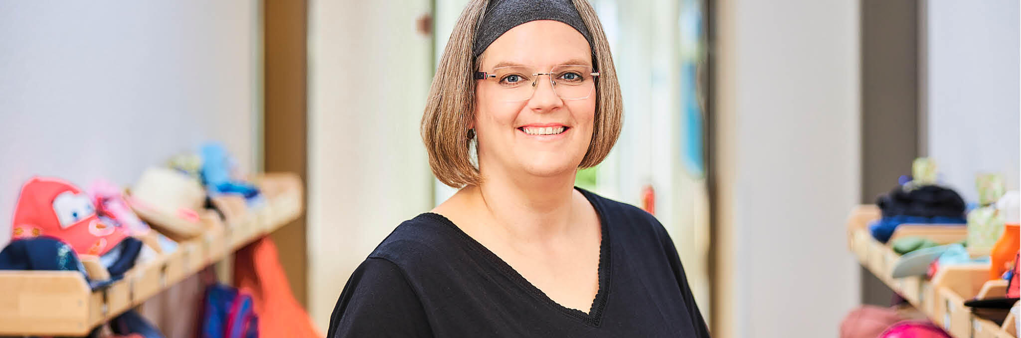 Eine Erzieherin steht an der Garderobe in der Johanniter-Kita