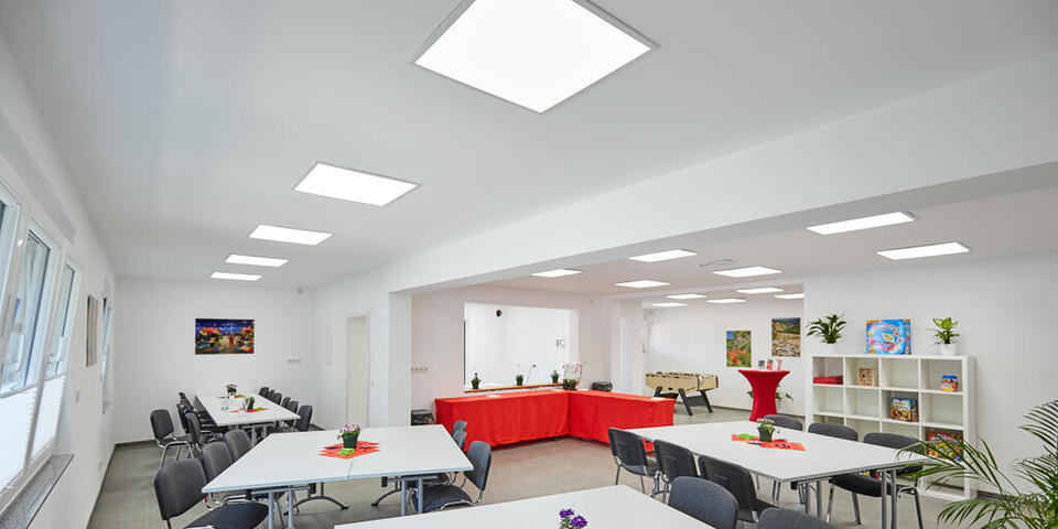 Innenansicht vom Hauptraum des Treffpunkt "vor Müllert" mit hellen Tischen