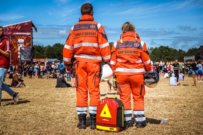 Zwei Einsatzkräfte im Sanitätsdienst von hinten