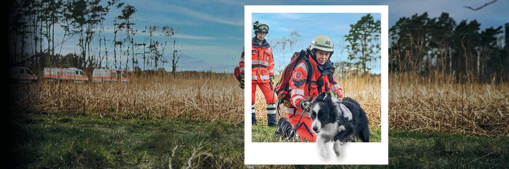 Ehrenamtliche Mitglieder einer Rettungshundestaffel in Einsatzkleidung auf freier Fläche