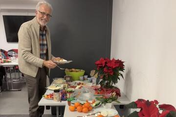 Mann vor reichhaltigem Frühstücksbuffet