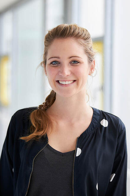 Eine junge Frau lächelt in die Kamera