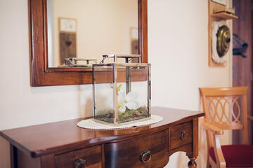 Wandspiegel und alte Kommode mit einem blumengeschmücktes Windlicht sorgen für Gemütlichkeit im Johanniter-Quartier Lübeck