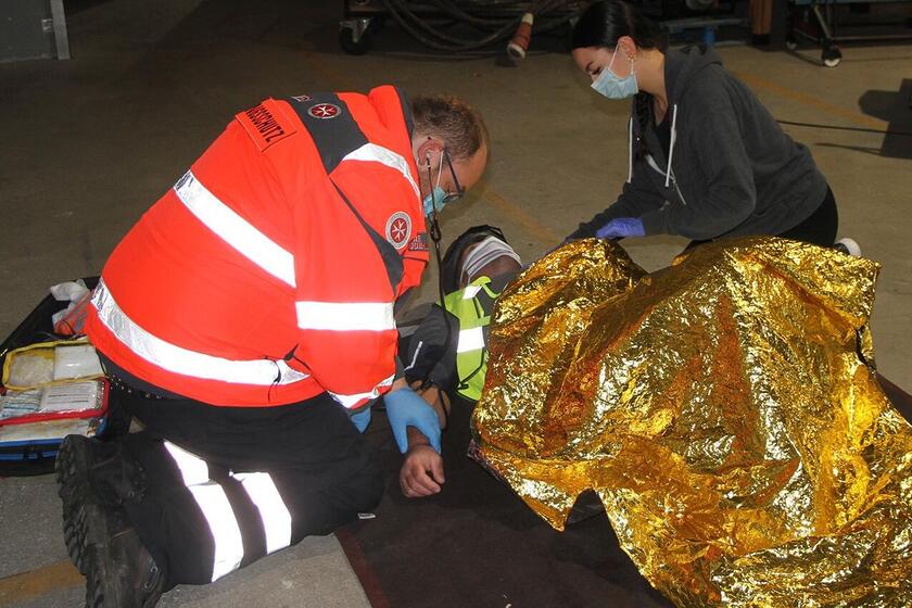 Zwei Helfende versorgen die verunfallte Person