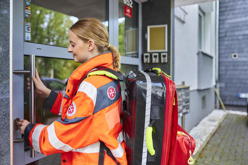 Frau vom Einsatzdienst sperrt eine Tür auf.