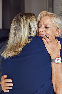 Eine Kundin des Hausnotruf umarmt eine Johanniter-Mitarbeiterin