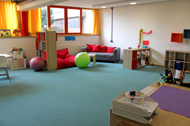 Gruppenraum mit gemütlicher Entspannungsecke, Spielen, Sitzgelegenheiten und Co. 