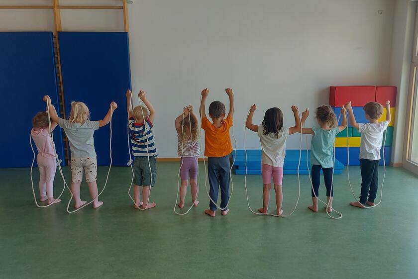 Die Kinder des Kindergartens haben Spaß in der Turnhalle.