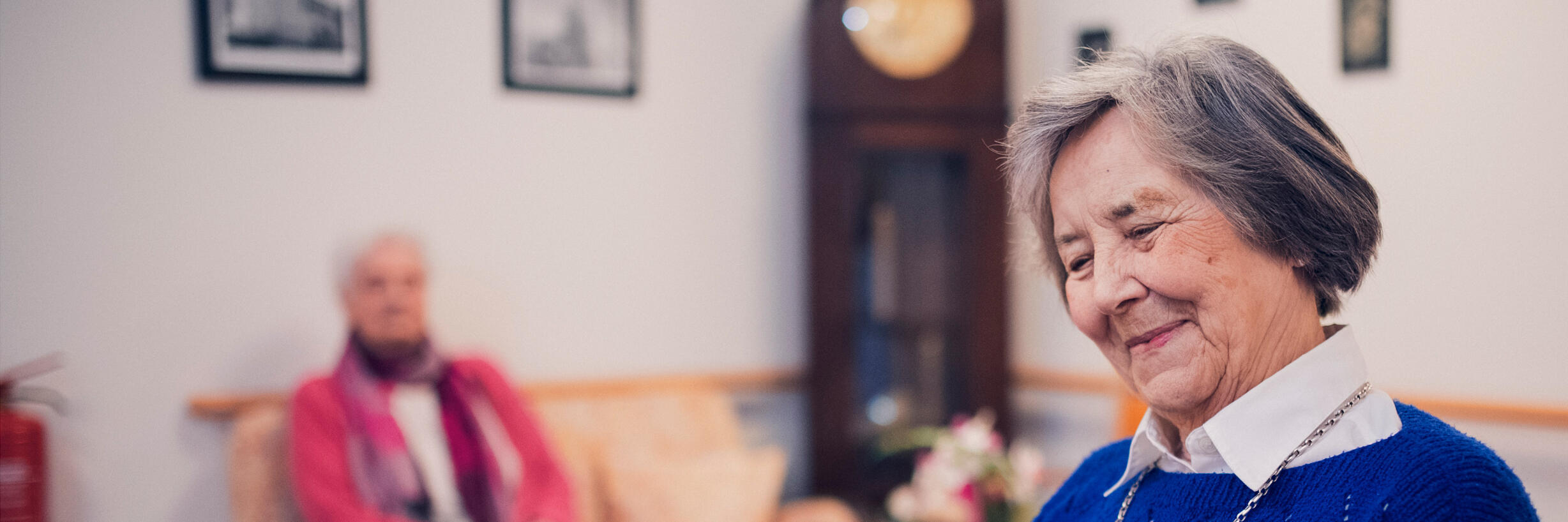 Eine Bewohnerin in blauem Pullover liest im Johanniter-Stift