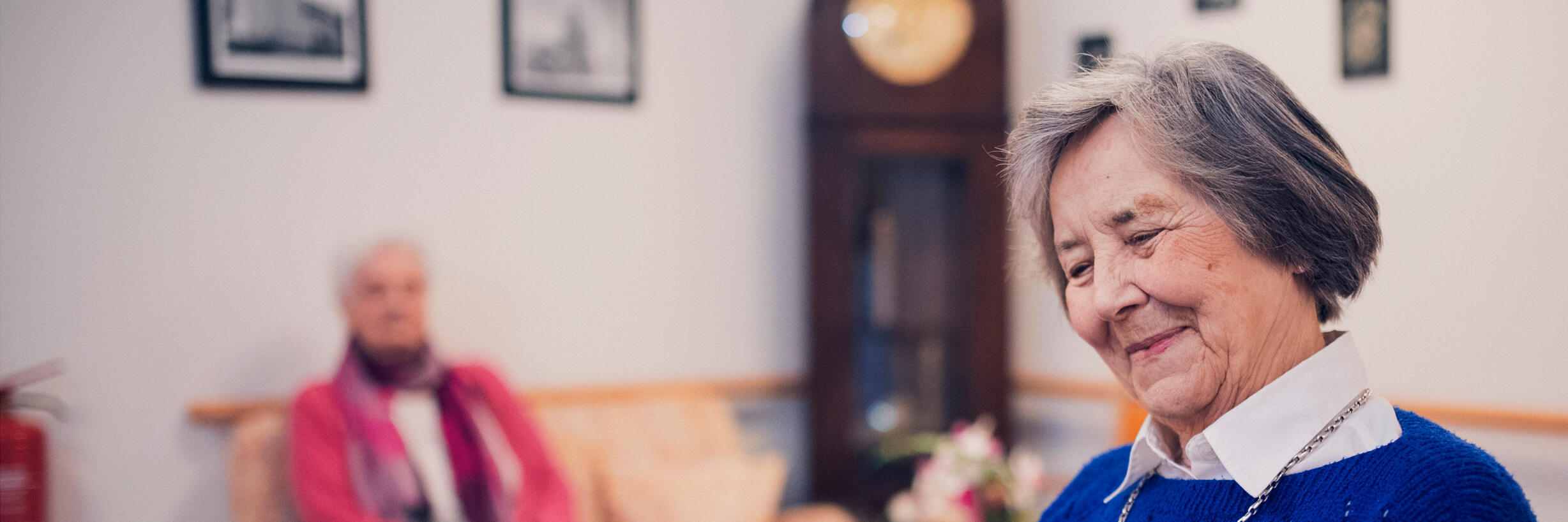 Eine Bewohnerin in blauem Pullover liest im Johanniter-Stift