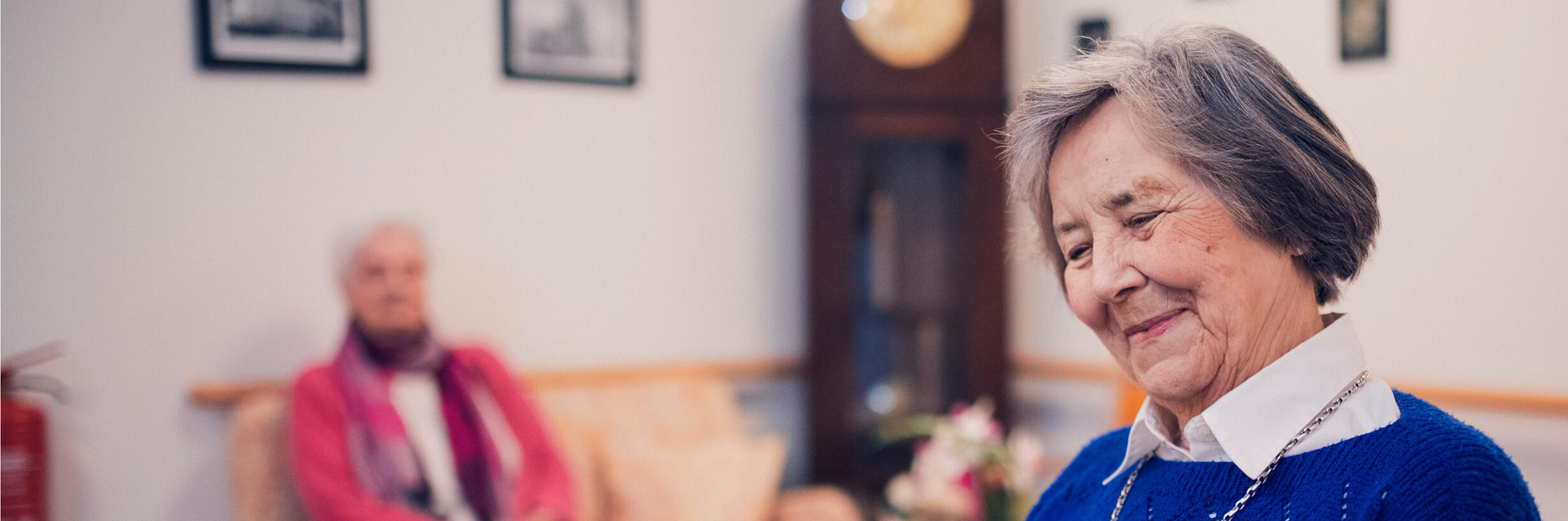 Eine Bewohnerin in blauem Pullover liest im Johanniter-Stift