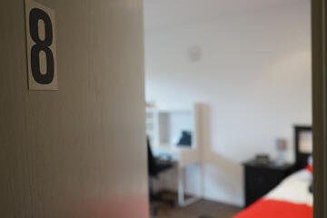 halb geöffnete Zimmertür mit Aufschrift "Acht"