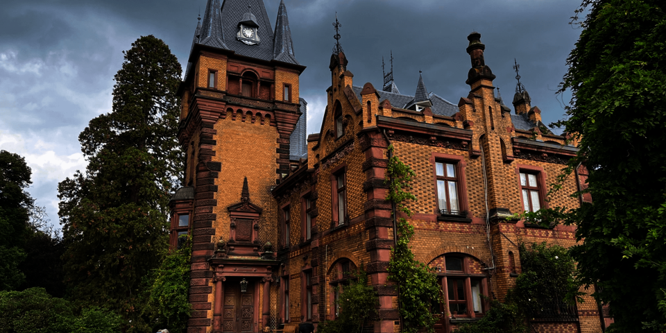 Menschen in Rollstühlen vor einem kleinen Schloss