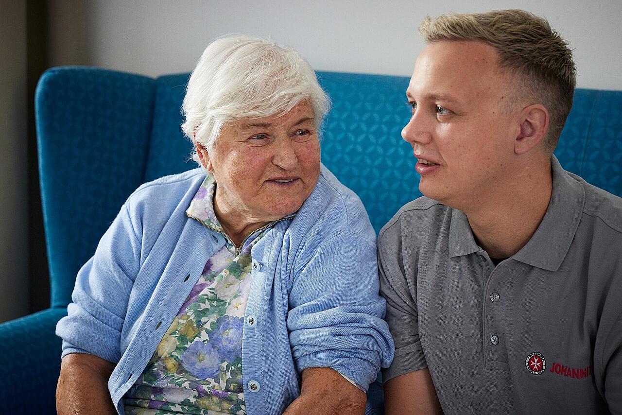 Pflegemitarbeitender und Seniorin