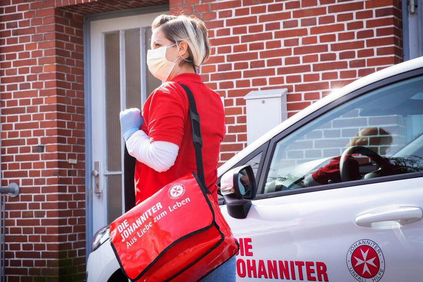 Johanniter-Pflegekraft mit Mundschutz